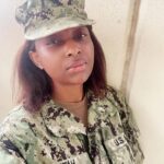 Actress, Grace Charis Bassey disassembling, cleaning her rifle after joining US military